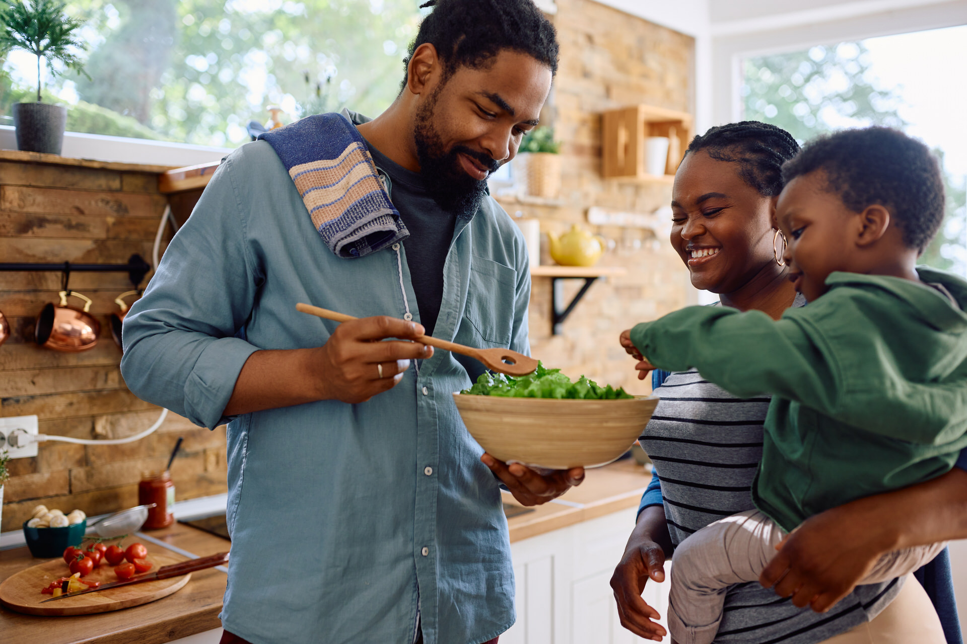 Happy African American Family Enjoying In Preparing Healthy Food In The Kitchen.